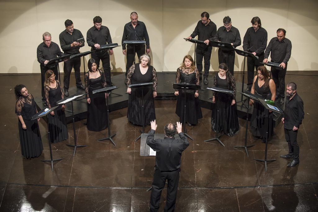 Camerata Vocal de la Universidad de Chile en formación semicircular, director frente a coro de voces profesionales
