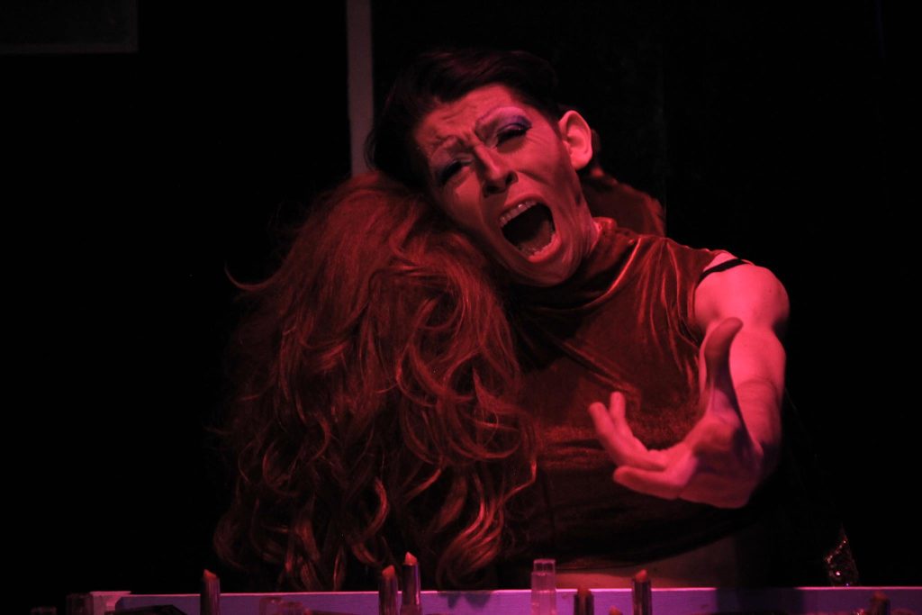 "Soledad": Un monólogo interno y biográfico Actor en escena bajo iluminación roja, interpretando un monólogo con expresión intensa y gesticulación dramática