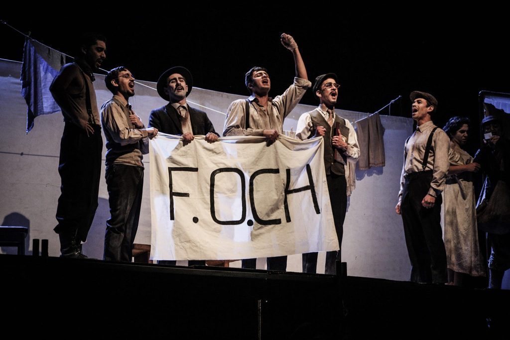 "Almas perdidas", en M100: La sensibilidad teatral de la Revolución Chilena Grupo de actores en escena sosteniendo pancarta con texto F.OCH durante presentación teatral de Almas perdidas