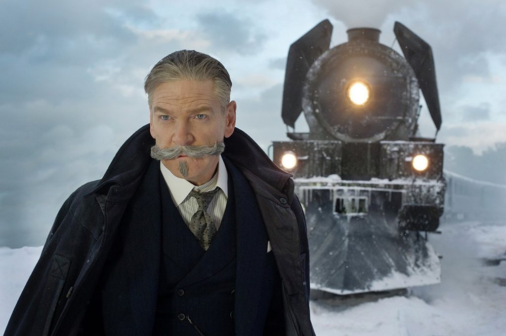 "Asesinato en el Orient Express": Con el sello dramático de un gran elenco Hombre mayor en abrigo oscuro frente a locomotora de vapor con luces encendidas en nieve
