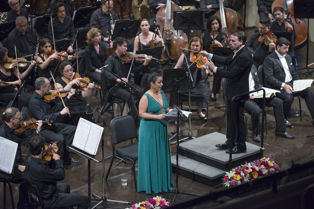 "Carmina Burana" en el aniversario de la Orquesta Sinfónica Nacional de Chile: Equilibrio vocal e instrumental Soprano en vestido verde canta ante orquesta sinfónica durante presentación de Carmina Burana