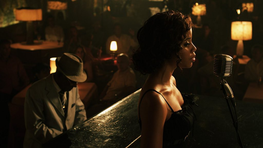 "7 días en La Habana": El alma audiovisual de la capital cubana Escena nocturna de estudio de grabación con cantante ante micrófono, ambiente cálido con iluminación dorada y vintage