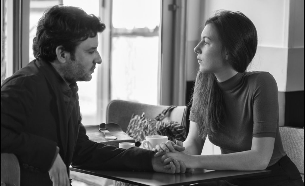 "Amantes por un día", de Philippe Garrel: Las tonalidades de la profundidad Dos actores en conversación íntima alrededor de una mesa, en fotografía en blanco y negro de Amantes por un día