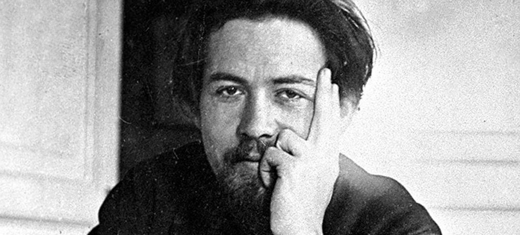 Retrato en blanco y negro del escritor ruso Anton Chéjov, con la mano cerca del rostro en gesto reflexivo