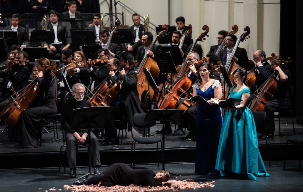 Soprano en vestido azul turquesa canta ante orquesta en escenario del Teatro Municipal, con músicos de fondo
