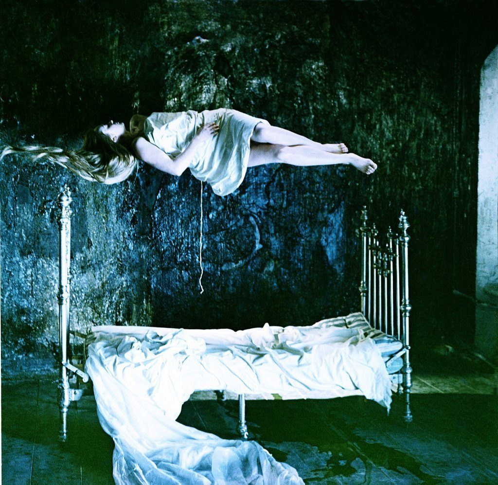 "El espejo", de Andrei Tarkovski: El surgir de la magia Hombre levitando sobre cama de hierro en habitación oscura con paredes verdes descascaradas, escena de El espejo