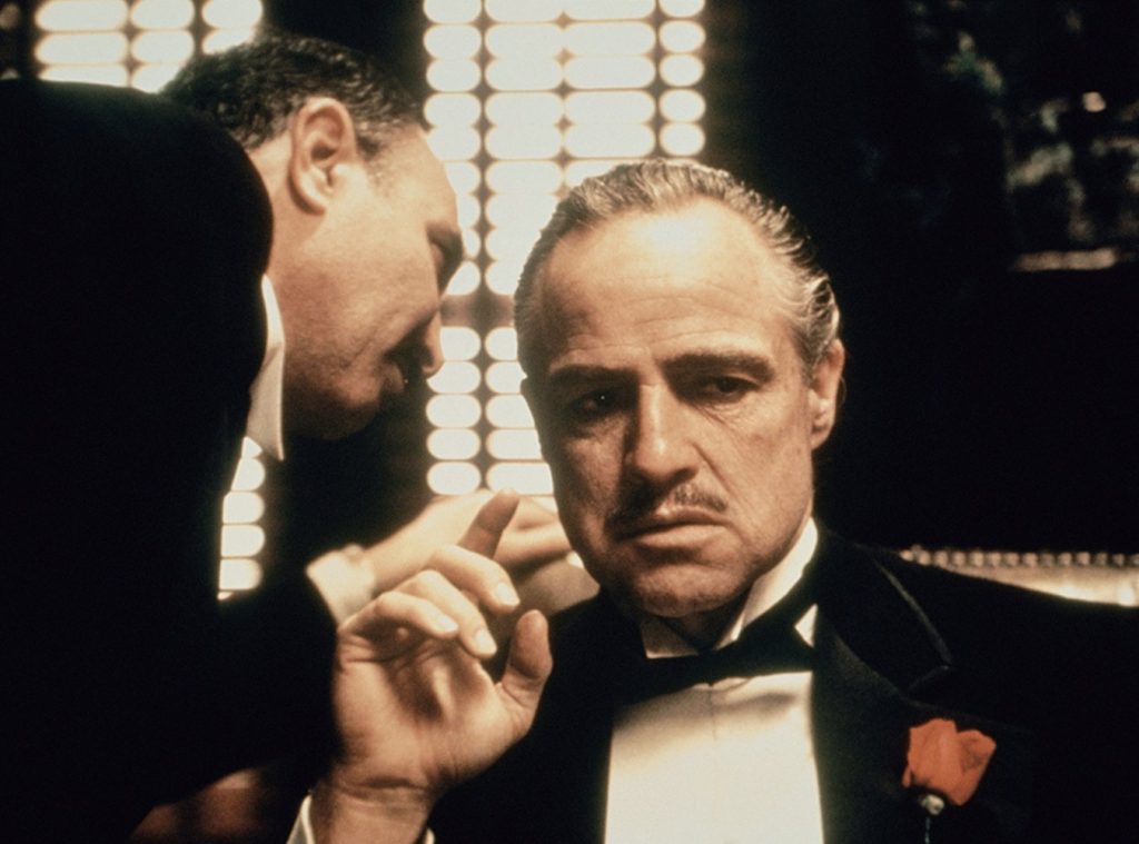 "El padrino", de Francis Ford Coppola: La unión hace la fuerza Marlon Brando interpreta al patriarca Vito Corleone en traje oscuro y corbata, fumando puro con expresión seria