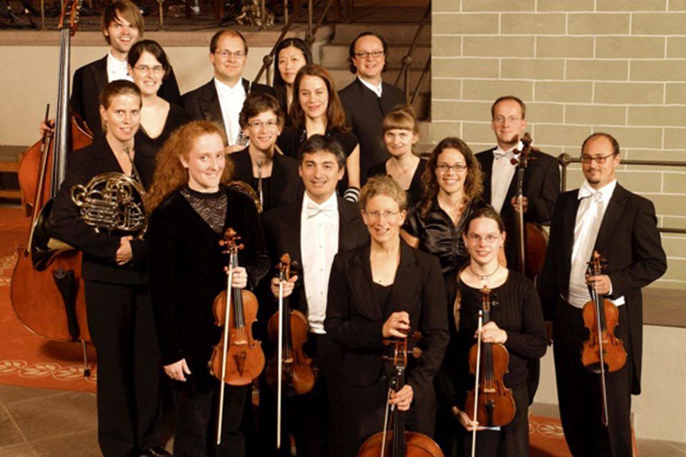 Orquesta Hofkapelle Weimar dirigida por Peter Hörr, músicos en traje negro con instrumentos de cuerda posando