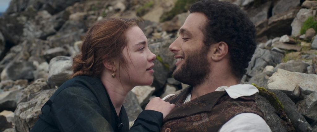"Lady Macbeth", de William Oldroyd: La insaciable sed del amor Dos personajes en primer plano frente a rocas, uno sostiene al otro por el cuello en gesto intenso y apasionado