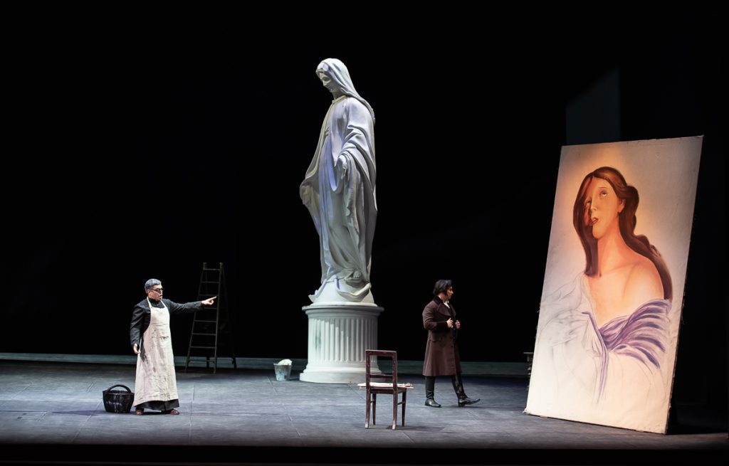 "Tosca", versión estelar en el Municipal de Santiago: La apuesta "dramática" de una régie ambiciosa Escena teatral de Tosca en el Municipal de Santiago: actriz frente a estatua clásica y retrato, ambiente dramático