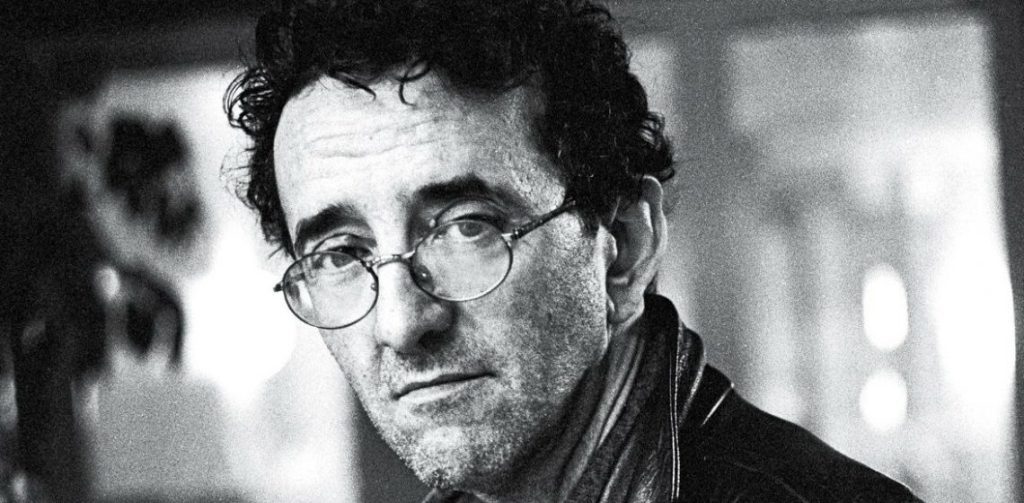SANFIC 14: "La biografía inventada", de Nicolás Lasnibat: El quiebre de los límites entre la realidad y la ficción Nicolás Lasnibat, escritor chileno, retrato en blanco y negro con gafas redondas y expresión seria