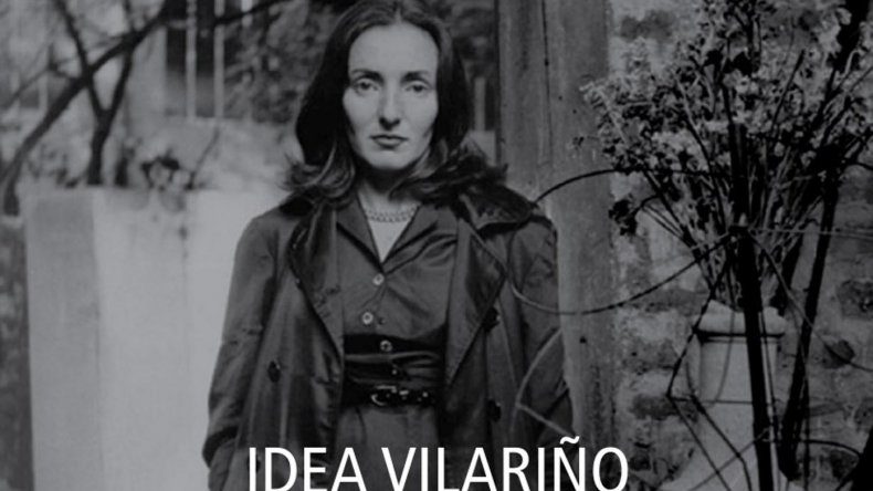 Idea Vilariño, poeta uruguaya, retratada en blanco y negro con abrigo oscuro y flores al fondo