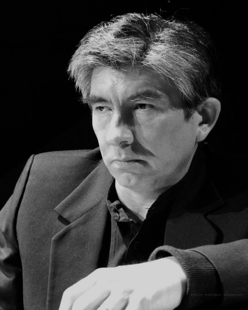 Mario Alarcón, pianista, retrato en blanco y negro de perfil tres cuartos mirando hacia la izquierda con traje