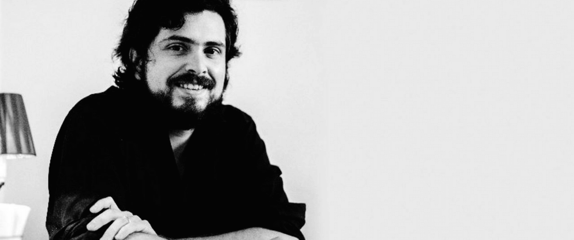 Retrato en blanco y negro de Andrés Montero, escritor chileno, apoyado sobre su brazo en actitud reflexiva