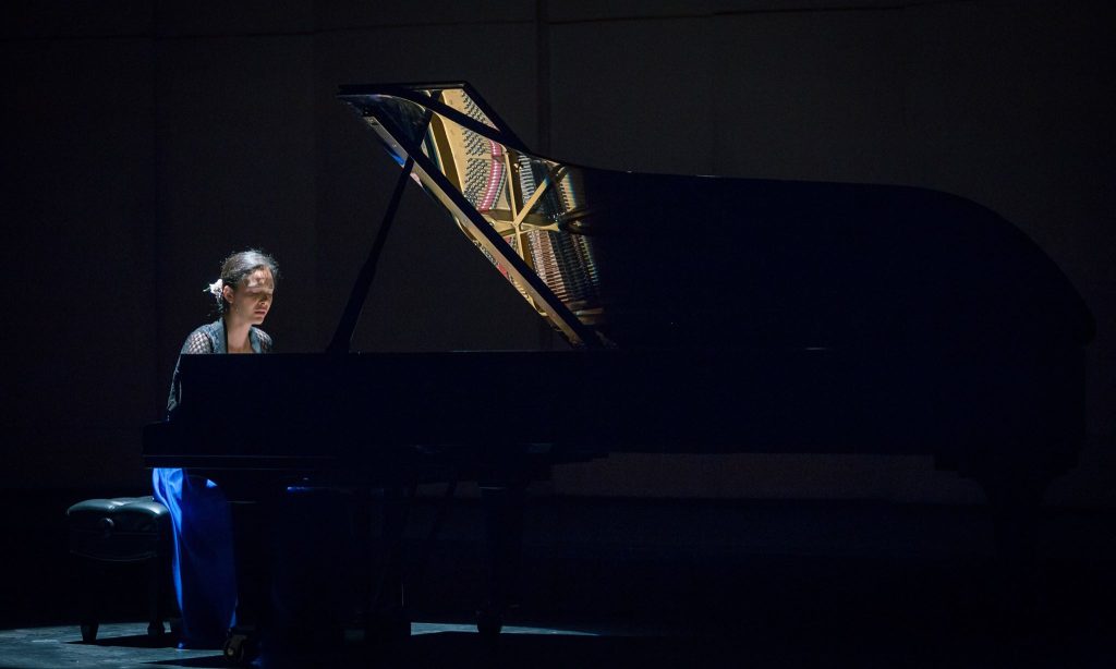 Grandes Pianistas en el Municipal de Santiago: La técnica sin pasión de Mahani Teave Pianista Mahani Teave sentado ante piano de cola en escena iluminada del Teatro Municipal de Santiago