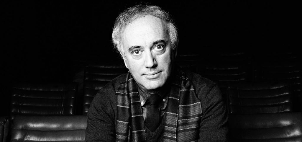 Jorge Díaz: Las creaciones de un visionario que desnudó al Chile de hoy Jorge Díaz, dramaturgo chileno, retratado en blanco y negro con expresión seria, vistiendo camisa a cuadros