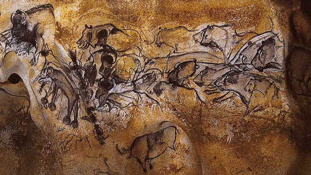 Pinturas rupestres de animales en tonos ocres y marrones sobre pared de piedra antigua, arte paleolítico