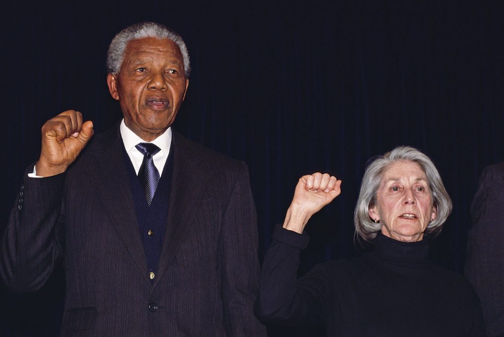 Nadine Gordimer: La interminable búsqueda de uno (a) mismo (a) Nelson Mandela y Nadine Gordimer con los puños en alto cantando el himno nacional, fondo oscuro