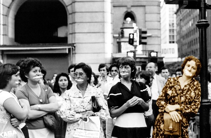 Grupo de mujeres en manifestación callejera frente a edificios, sostienen pancartas durante protesta feminista en Chile