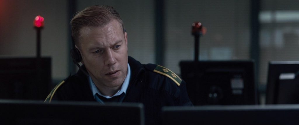 "La culpa": La profundidad sicológica de una cámara Hombre de uniforme militar ante pantalla de computadora en sala de control, expresión seria y concentrada