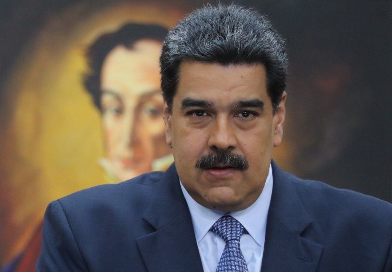 "Septiembre, poemas de amor, pasión y rebelión": La lírica del exilio venezolano en Chile Hombre con traje azul y corbata gris ante retrato al fondo, en ambiente de oficina formal