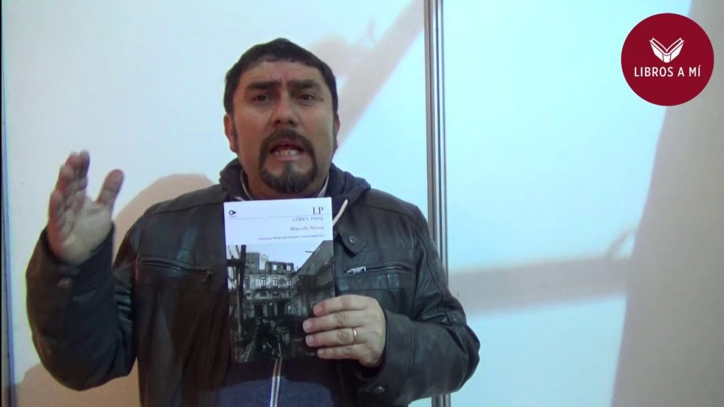 Marcelo Novoa gesticula mientras sostiene un papel durante una presentación, con pantalla de fondo