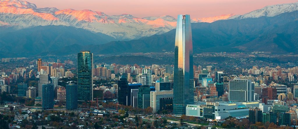 Skyline de Santiago de Chile al atardecer con la Cordillera de los Andes nevada de fondo y edificios modernos