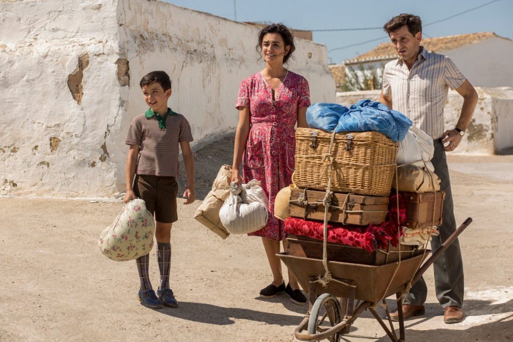 Familia con carreta de frutas y verduras en camino de tierra, ambiente desértico y árido, escena de neorrealismo