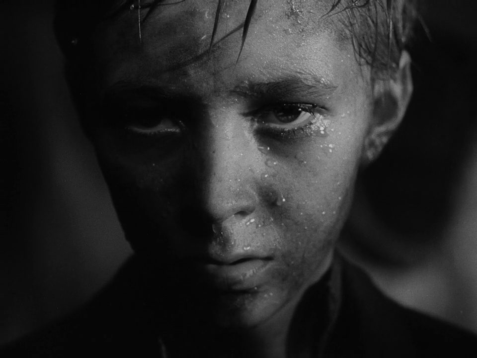 "La infancia de Iván", de Andrei Tarkovsky : El contenido de lo oculto Retrato en blanco y negro de un joven con expresión seria y mirada intensa, iluminación dramática característica