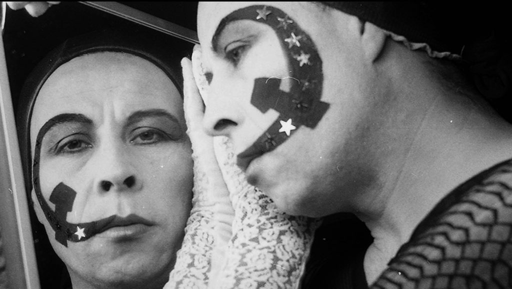 Pedro Lemebel con maquillaje artístico y expresión teatral, retrato en blanco y negro