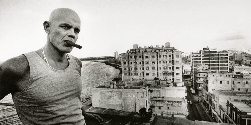 "Estoico y frugal", de Pedro Juan Gutiérrez: La soledad de una pasión animal Pedro Juan Gutiérrez en un tejadillo de La Habana, cigarrillo en mano, con edificios de fondo