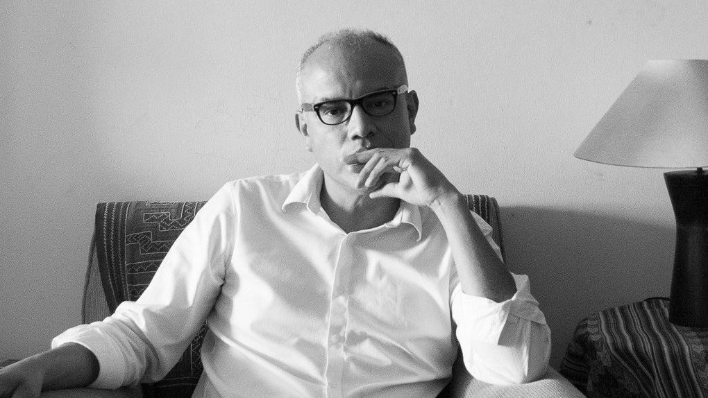 "Moridor y otros poemas", de Willy Gómez Migliaro: El habla carga sus muertos Willy Gómez Migliaro, poeta chileno, sentado en un sofá gris, vistiendo camisa blanca y lentes, con gesto pensativo