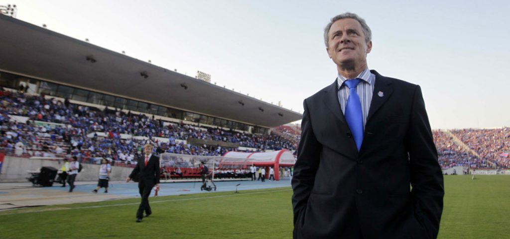 "Militarizar una prueba resistida": La cruzada de Federico Valdés Federico Valdés en traje y corbata azul de pie en el césped de un estadio con tribunas al fondo