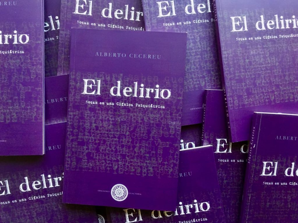 Múltiples ejemplares del libro El delirio de Alberto Cecereu apilados mostrando portadas en tonos púrpura