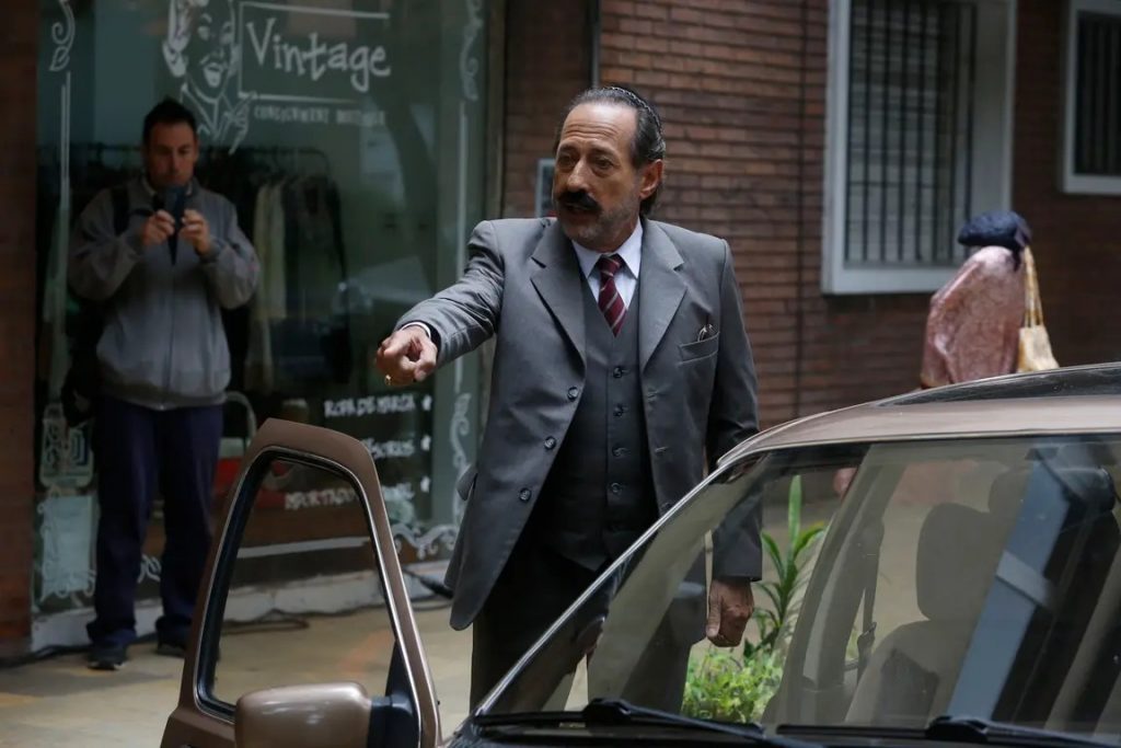 "El robo del siglo": Un espectáculo audiovisual inspirado en Latinoamérica Hombre de traje y gafas junto a un taxi en la calle, escena de la película El robo del siglo