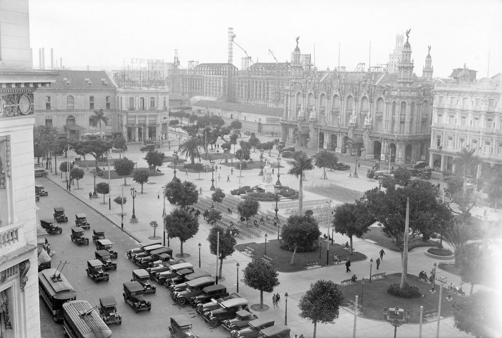 Plaza con edificios históricos, tranvías y automóviles antiguos, La Habana años 20, Capitolio al fondo
