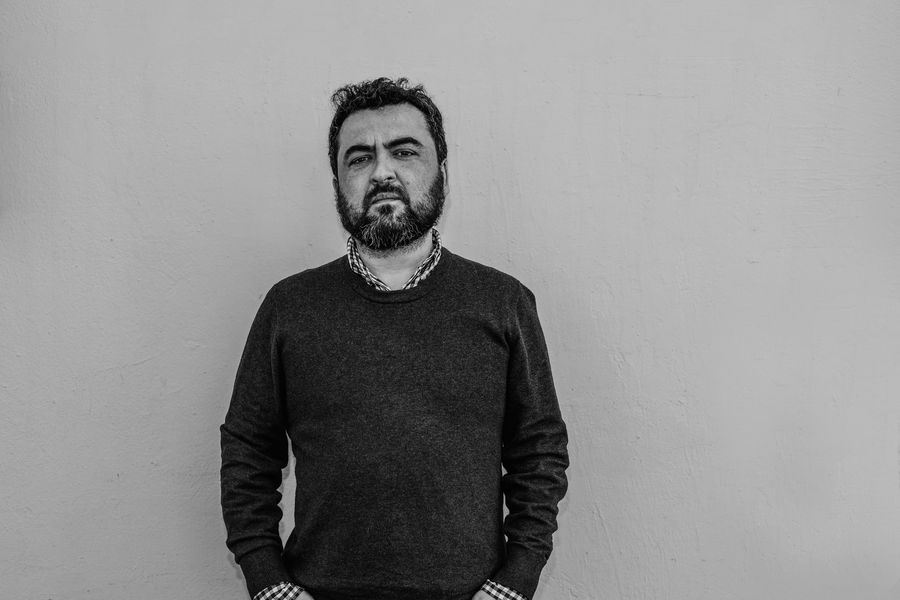 "Antes de que fuera octubre", de Óscar Contardo: En contra de una élite neoliberal Óscar Contardo, escritor chileno con barba y cabello oscuro, viste suéter negro en fotografía de estudio con fondo gris
