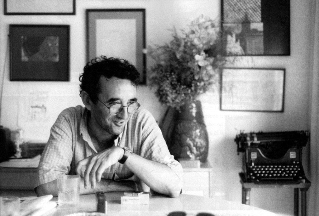 Roberto Bolaño, escritor chileno, en su escritorio con máquina de escribir y documentos, años setenta