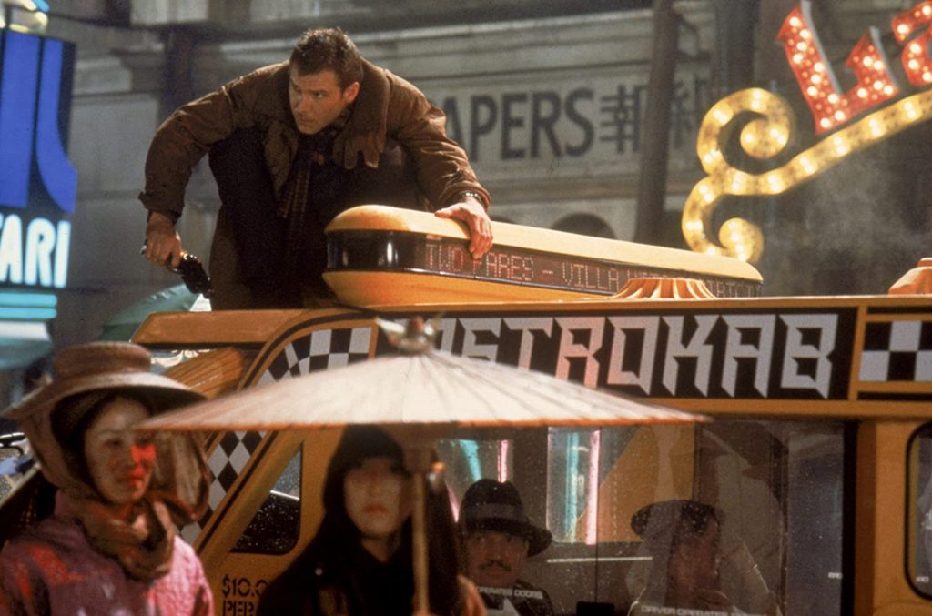 "Blade Runner": Una de las obras maestras de Ridley Scott cumple 38 años Ridley Scott ajusta una escena en el set de filmación, con actores y equipo técnico observando detrás de una baranda