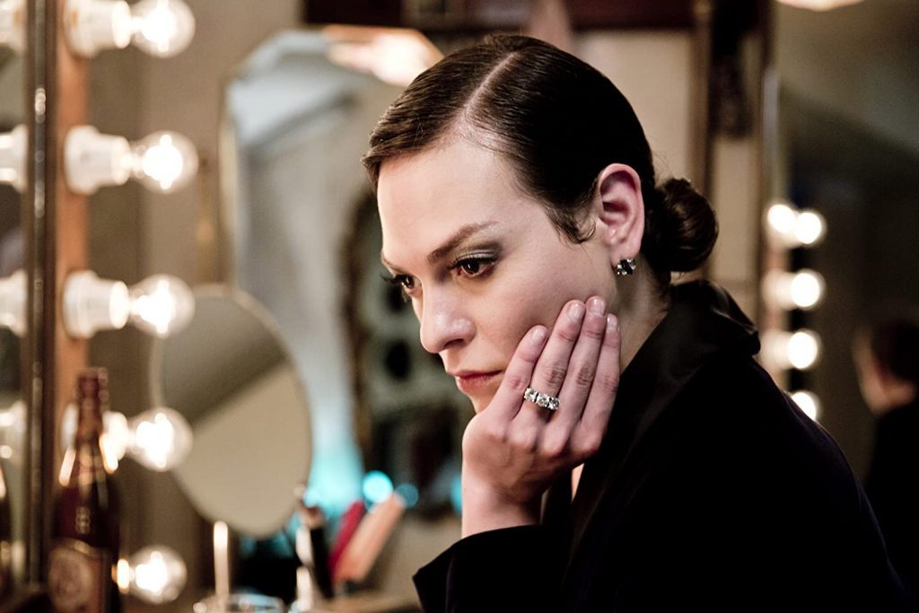 Mujer maquillándose frente a espejo iluminado, escena del filme Una mujer fantástica