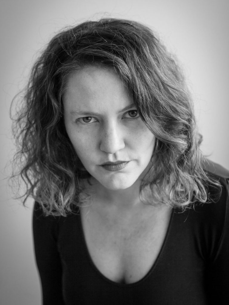 "Rudas", de Carolina Brown: No hay tiempos para lamentos Retrato en blanco y negro de Carolina Brown, autora, con cabello ondulado y expresión seria mirando hacia la cámara