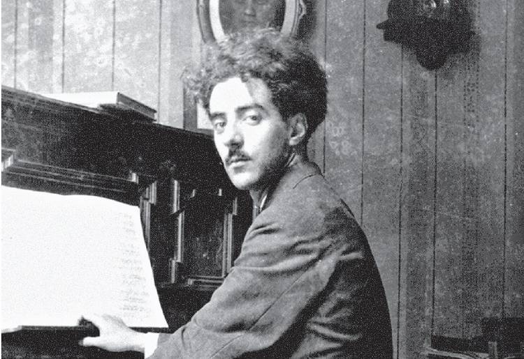 Felisberto Hernández sentado frente a un piano de cola, mirando hacia la cámara en blanco y negro
