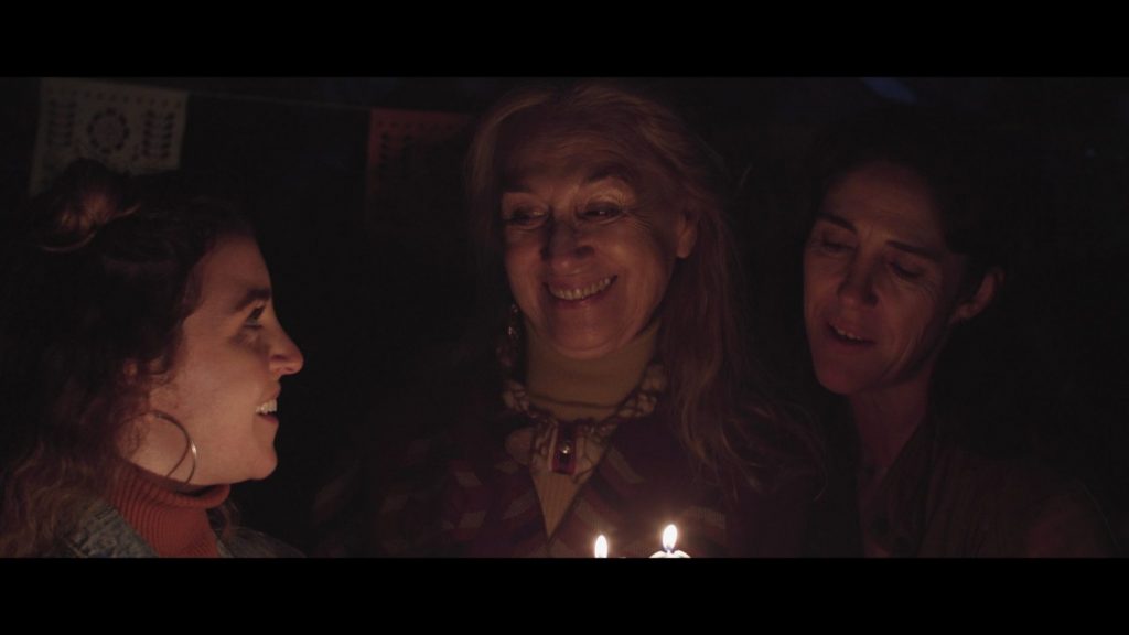 SANFIC 16: "Las mujeres de mi casa": La extinción del tiempo Tres mujeres alrededor de velas encendidas en la oscuridad, en escena íntima y dramática de la película Las mujeres