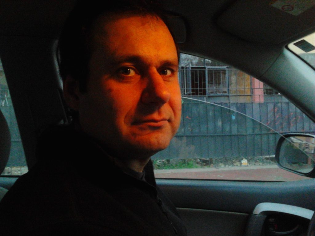 Aníbal Ricci, crítico de cine y literatura, en primer plano dentro de un automóvil con iluminación cálida