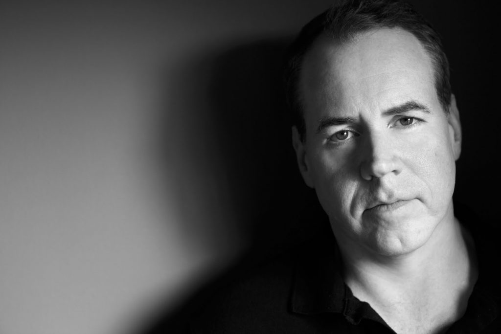 Retrato en blanco y negro de Bret Easton Ellis, autor estadounidense, mirando hacia la cámara con expresión seria