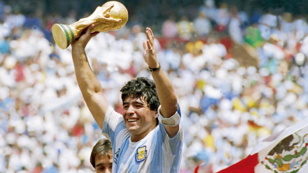 Diego Maradona levanta la Copa del Mundo con ambas manos, vistiendo la camiseta azul de Argentina
