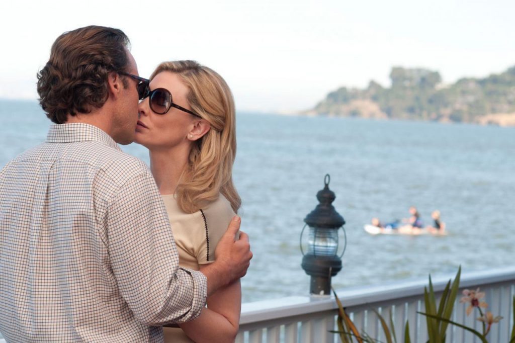 Pareja besándose en un balcón junto al mar, escena de la película Blue Jasmine de Woody Allen