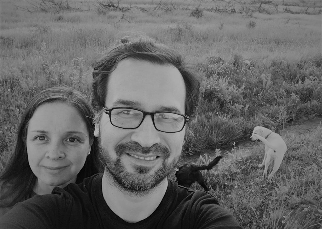 Cruz Villalobos junto a una mujer en un campo abierto, ambos sonriendo hacia la cámara en fotografía en blanco y negro