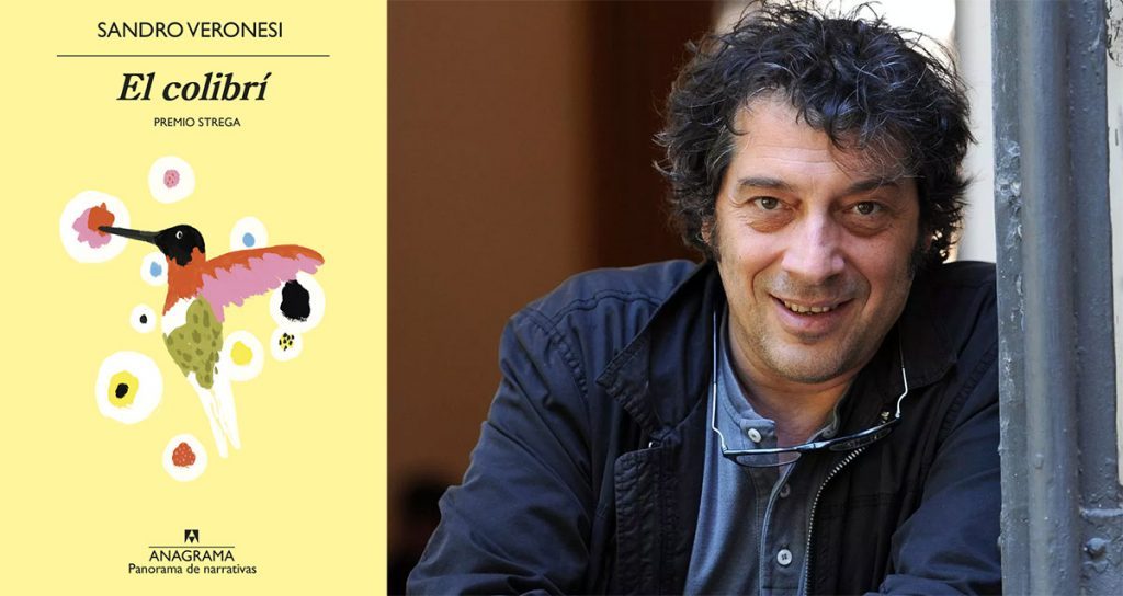 Sandro Veronesi, escritor italiano, junto a la portada de su novela El colibrí con ilustración de un colibrí