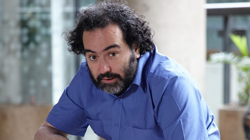 Rafael Gumucio, escritor y director chileno, con barba y cabello rizado, vistiendo camisa azul